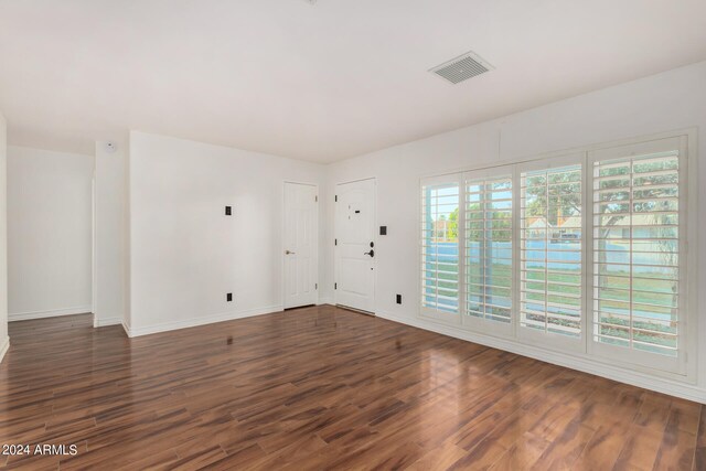 empty room featuring dark hardwood / wood-style flooring and a healthy amount of sunlight