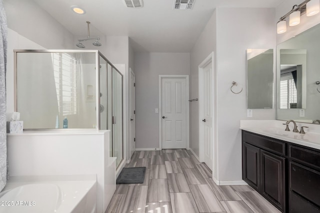 full bathroom with a stall shower, baseboards, visible vents, vanity, and a bath