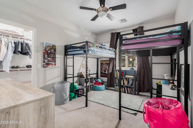 carpeted bedroom with ceiling fan, visible vents, and a closet