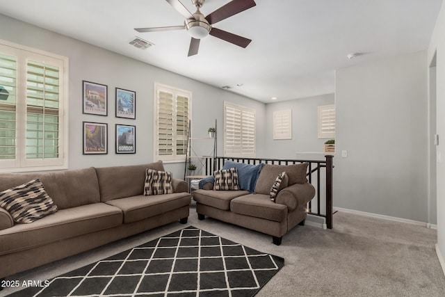 living area featuring a ceiling fan, carpet, visible vents, and baseboards