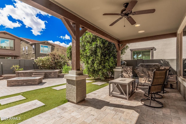 view of patio featuring a fenced backyard, an outdoor hot tub, and a ceiling fan