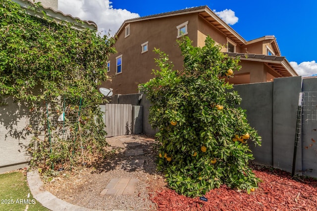 view of home's exterior with fence and stucco siding