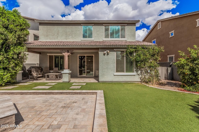 rear view of property with a tile roof, a patio, stucco siding, ceiling fan, and fence