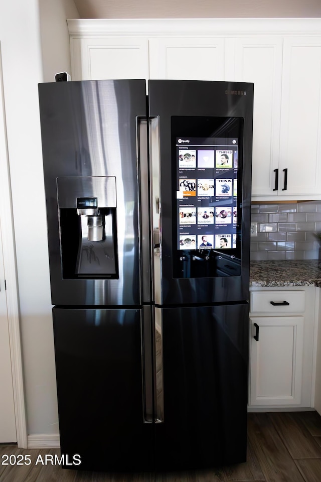 1364 W Spine Tree Ave, Queen Creek, AZ 85140 - kitchen view of fridge with ice dispenser, white cabinetry, light stone counters, backsplash, and dark wood finished floors