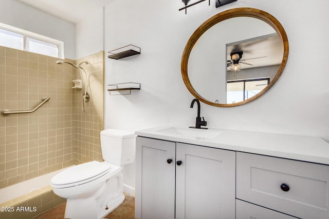 bathroom featuring tiled shower, ceiling fan, vanity, and toilet