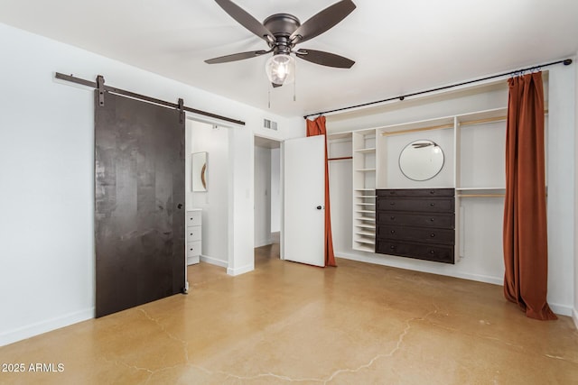 unfurnished bedroom with concrete floors, a barn door, and ceiling fan