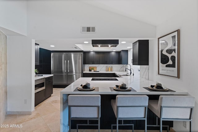1509 W Kiowa Ave, Mesa, AZ 85202 - kitchen with high quality fridge, dark cabinets, light countertops, lofted ceiling, and a peninsula