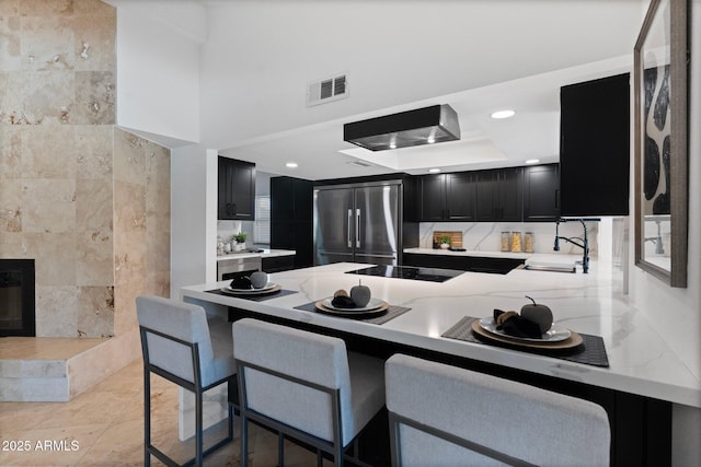1509 W Kiowa Ave, Mesa, AZ 85202 - kitchen featuring dark cabinetry, high end refrigerator, a peninsula, recessed lighting, and a kitchen bar