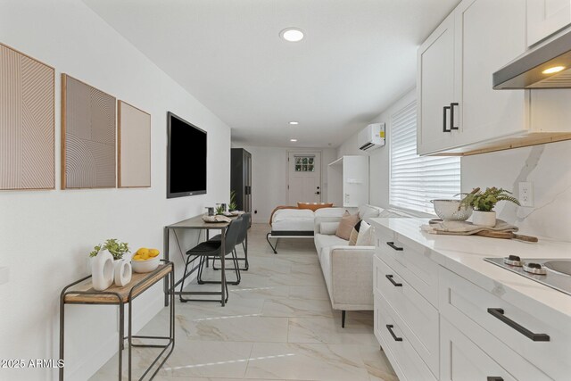1509 W Kiowa Ave, Mesa, AZ 85202 - kitchen with under cabinet range hood, a wall mounted AC, light marble finish flooring, white cabinetry, and recessed lighting