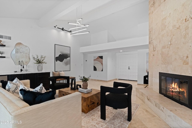 1509 W Kiowa Ave, Mesa, AZ 85202 - living area with a tiled fireplace, beamed ceiling, a high ceiling, and a chandelier