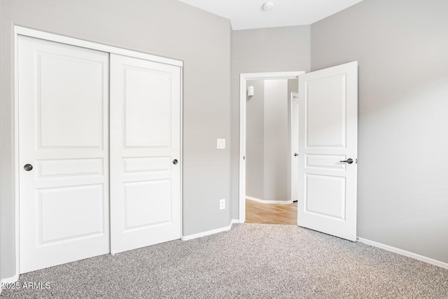 unfurnished bedroom featuring light colored carpet and a closet