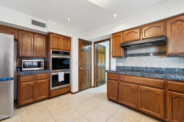6208 E Paradise Ln, Scottsdale, AZ 85254 - kitchen featuring stainless steel appliances, under cabinet range hood, tasteful backsplash, and visible vents
