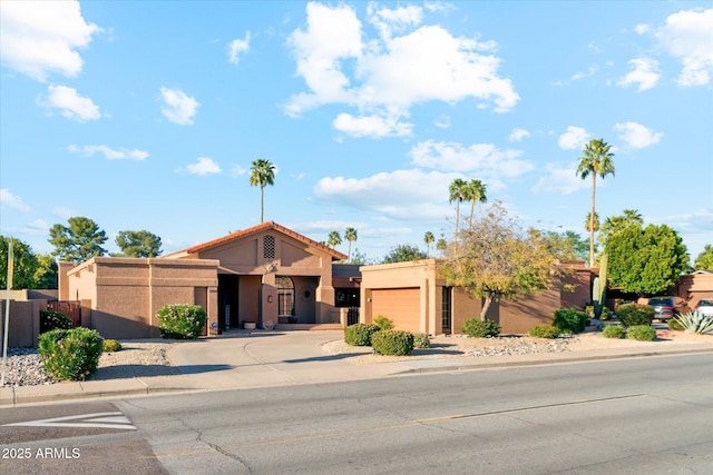 6208 E Paradise Ln, Scottsdale, AZ 85254 - view of front of house featuring curved driveway, a garage, and stucco siding