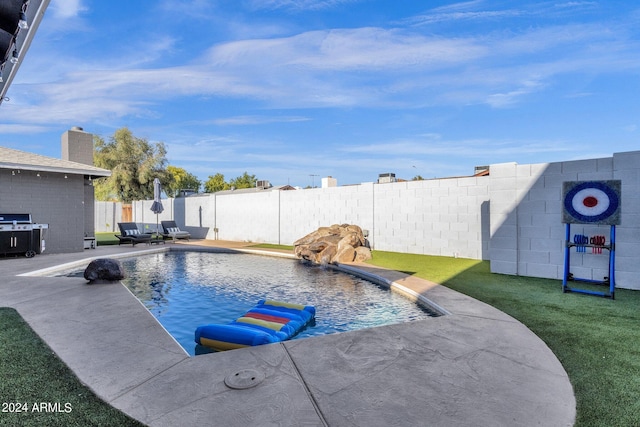 view of swimming pool with a patio, a yard, and pool water feature