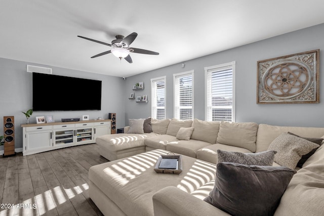 living room featuring ceiling fan and dark wood-type flooring