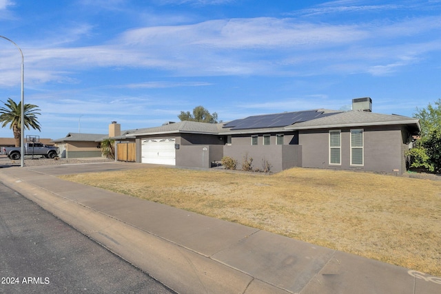 ranch-style home featuring a garage and a front lawn