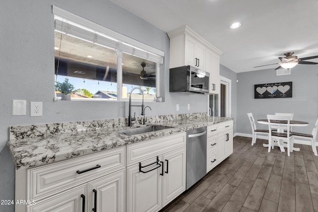 kitchen featuring white cabinetry, dark hardwood / wood-style flooring, stainless steel appliances, ceiling fan, and sink