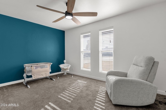 sitting room with ceiling fan and carpet flooring