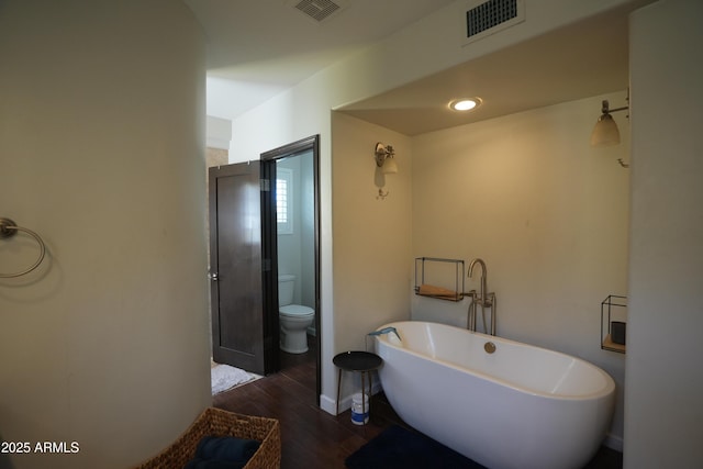 bathroom featuring wood-type flooring, toilet, and a bathing tub