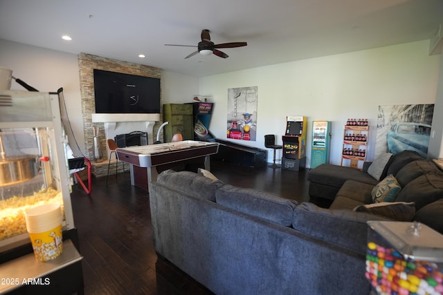 living room with dark wood-type flooring, a fireplace, and ceiling fan