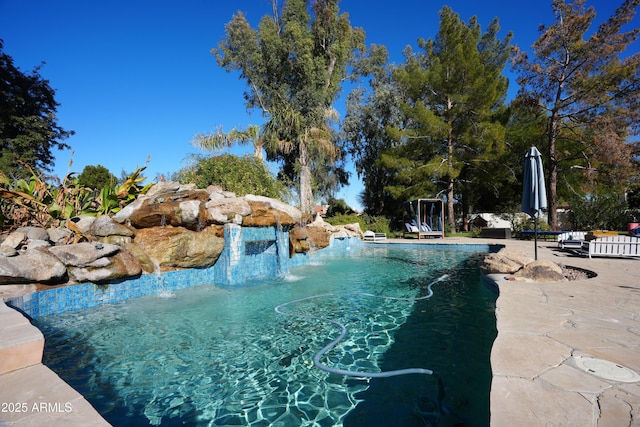 view of pool with pool water feature and a patio