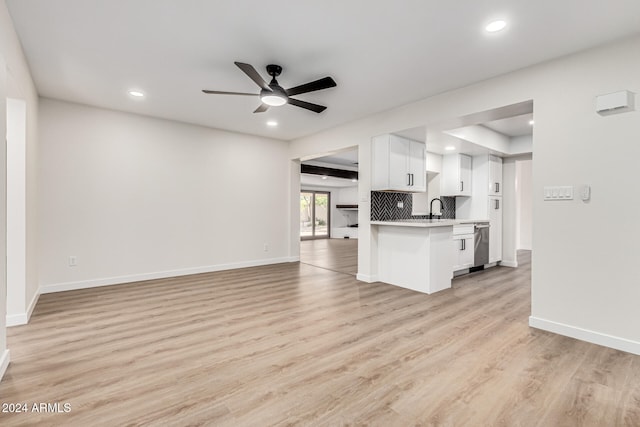 unfurnished living room with ceiling fan, sink, and light hardwood / wood-style floors