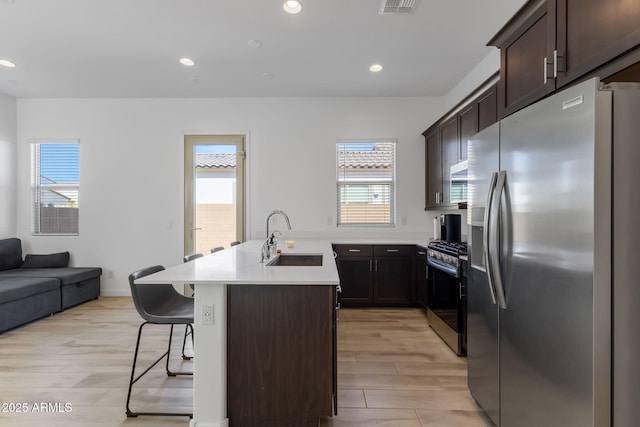 3885 E Kenley Ln, San Tan Valley, AZ 85143 - kitchen with appliances with stainless steel finishes, a sink, a kitchen bar, healthy amount of natural light, and recessed lighting