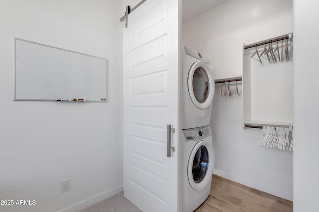 3885 E Kenley Ln, San Tan Valley, AZ 85143 - washroom featuring stacked washer / drying machine, baseboards, and light wood-style flooring