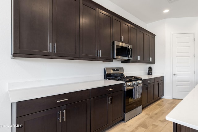 3885 E Kenley Ln, San Tan Valley, AZ 85143 - kitchen featuring appliances with stainless steel finishes, light countertops, dark brown cabinets, light wood-type flooring, and recessed lighting