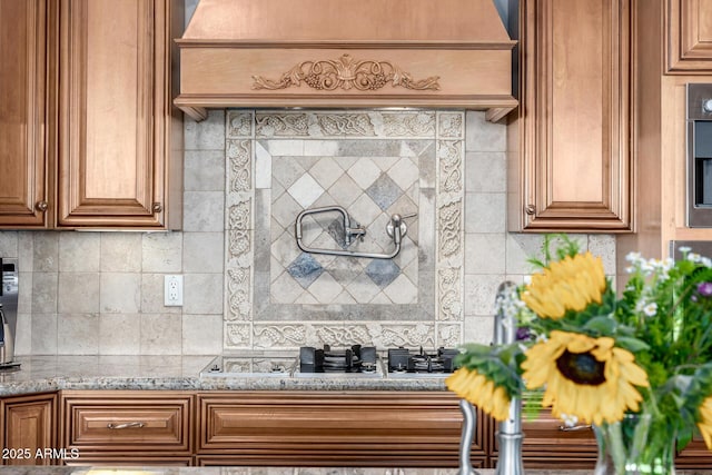 4328 N Pinnacle Ridge Cir, Mesa, AZ 85207 - kitchen featuring light stone counters, backsplash, stainless steel gas cooktop, and brown cabinets
