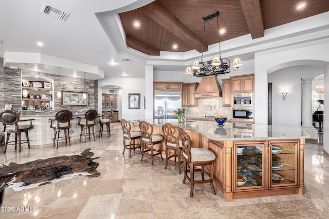 4328 N Pinnacle Ridge Cir, Mesa, AZ 85207 - kitchen featuring arched walkways, stainless steel built in fridge, wood ceiling, a breakfast bar area, and brown cabinets