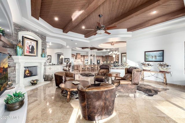 4328 N Pinnacle Ridge Cir, Mesa, AZ 85207 - living room with ceiling fan, wood ceiling with exposed beams, a warm lit fireplace, a raised ceiling, and a chandelier