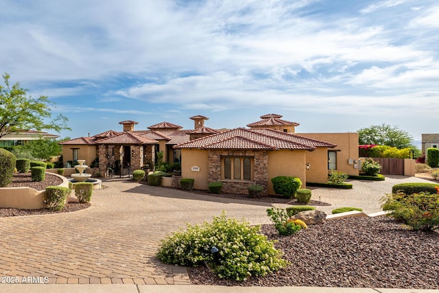 4328 N Pinnacle Ridge Cir, Mesa, AZ 85207 - mediterranean / spanish-style home with stucco siding, stone siding, curved driveway, a tiled roof, and a chimney