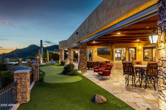 4328 N Pinnacle Ridge Cir, Mesa, AZ 85207 - patio terrace at dusk with a putting area, a patio, a ceiling fan, and a mountain view