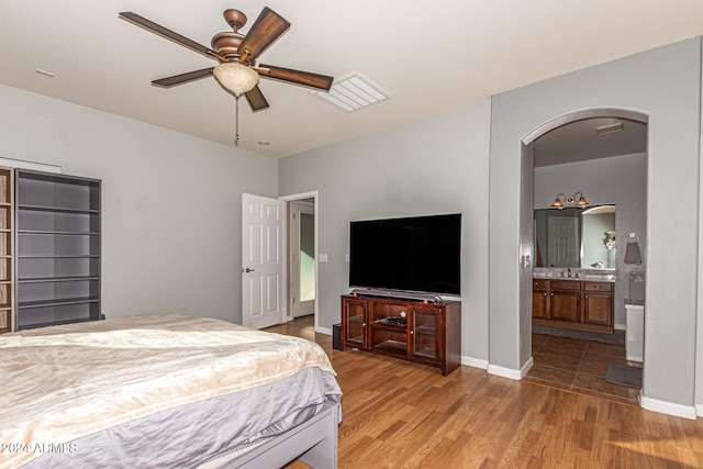 bedroom with light hardwood / wood-style floors, ceiling fan, and ensuite bathroom