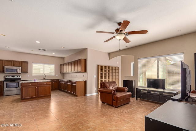 tiled living room with ceiling fan and sink