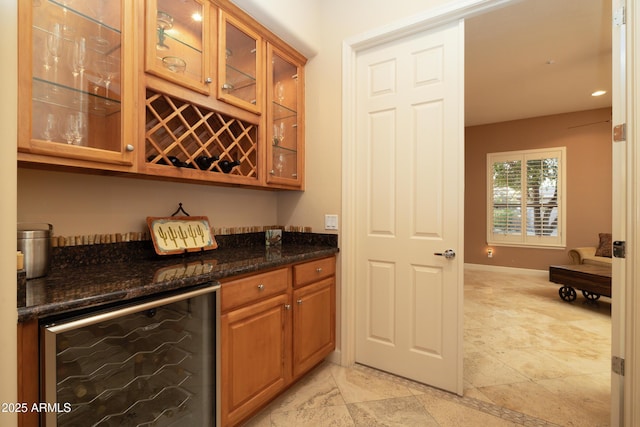 bar featuring a bar, beverage cooler, and baseboards