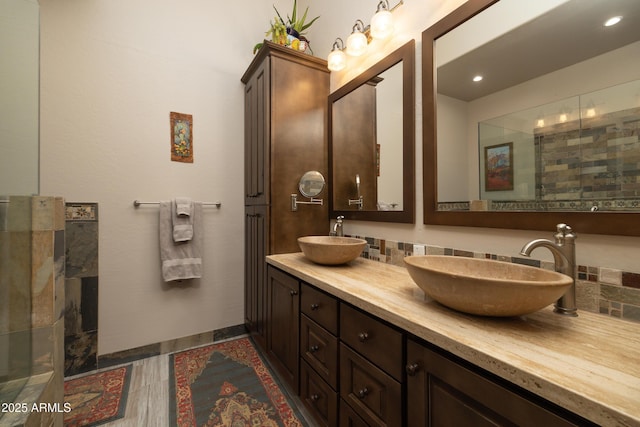 full bath with double vanity, decorative backsplash, and a sink