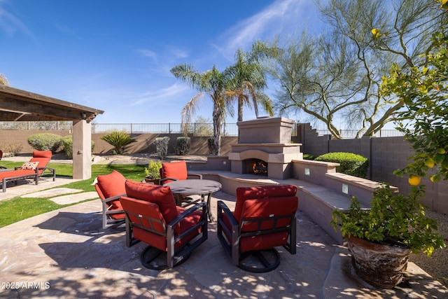 view of patio with a warm lit fireplace and a fenced backyard