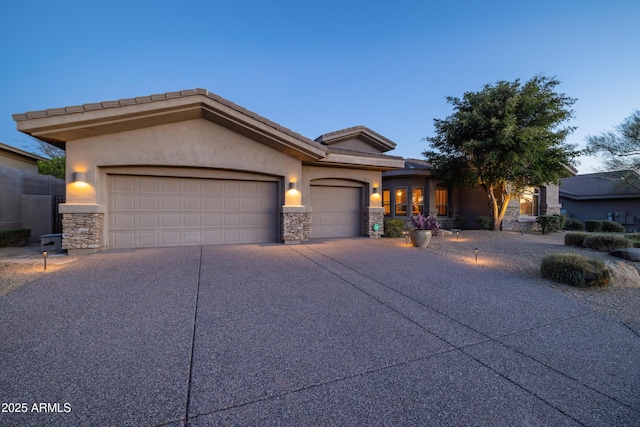 view of front facade featuring a garage, stone siding, concrete driveway, and stucco siding