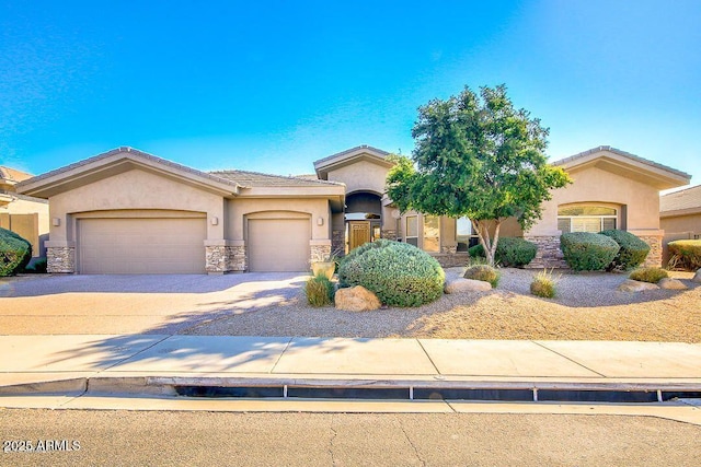 view of front of property with stone siding, an attached garage, driveway, and stucco siding