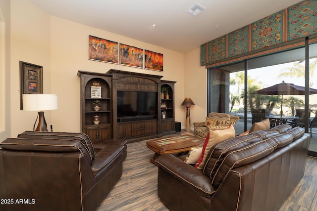 living area with visible vents and wood finished floors