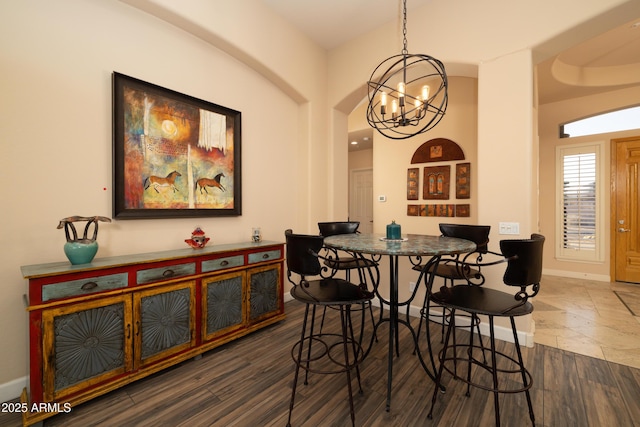 dining room with a chandelier, baseboards, and wood finished floors