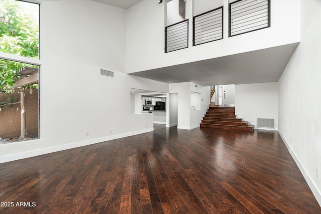 4434 E Camelback Rd Unit 132, Phoenix, AZ 85018 - unfurnished living room with stairway, wood-type flooring, and a high ceiling