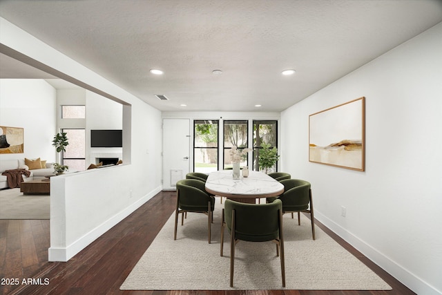 4434 E Camelback Rd Unit 132, Phoenix, AZ 85018 - dining space with a fireplace, dark wood-style floors, and recessed lighting