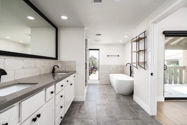 4434 E Camelback Rd Unit 132, Phoenix, AZ 85018 - full bathroom featuring double vanity, a soaking tub, recessed lighting, a stall shower, and decorative backsplash