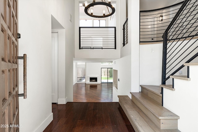 4434 E Camelback Rd Unit 132, Phoenix, AZ 85018 - foyer entrance with a high ceiling, wood-type flooring, stairway, a chandelier, and a fireplace with raised hearth