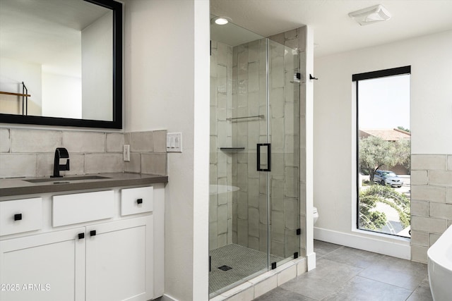 4434 E Camelback Rd Unit 132, Phoenix, AZ 85018 - bathroom featuring a shower stall, vanity, a freestanding bath, tasteful backsplash, and tile patterned flooring