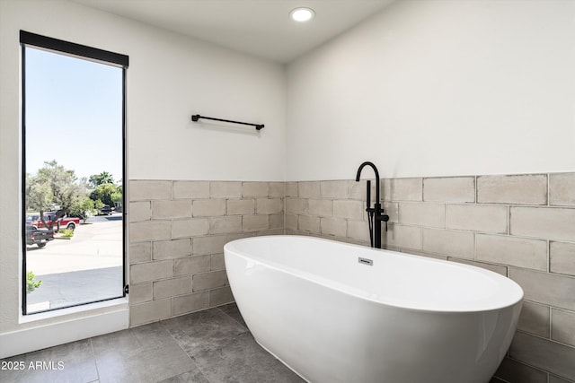 4434 E Camelback Rd Unit 132, Phoenix, AZ 85018 - full bath featuring tile walls, a soaking tub, and a wainscoted wall