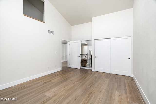 4434 E Camelback Rd Unit 132, Phoenix, AZ 85018 - unfurnished bedroom with high vaulted ceiling, light wood-style flooring, and a closet